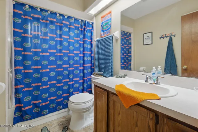 a bathroom with a sink a toilet and shower curtain