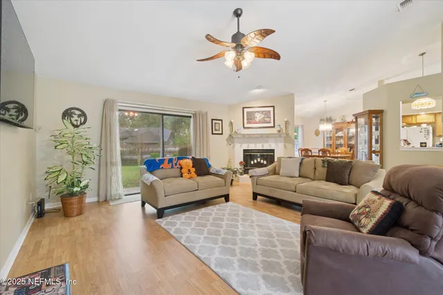 a living room with furniture kitchen view and a large window