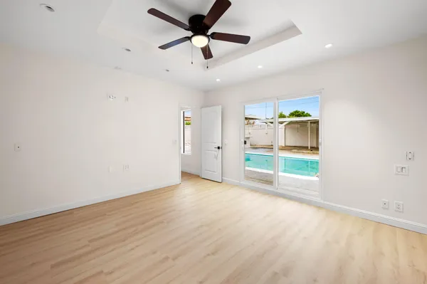an empty room with a ceiling fan and wooden floor