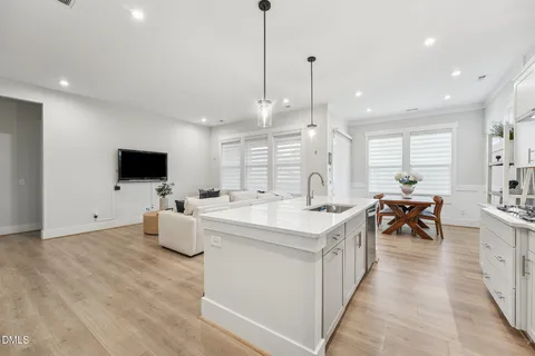 a kitchen with stainless steel appliances a dining table chairs stove refrigerator and microwave