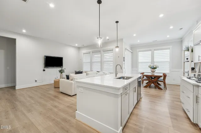 a kitchen with stainless steel appliances a dining table chairs stove refrigerator and microwave