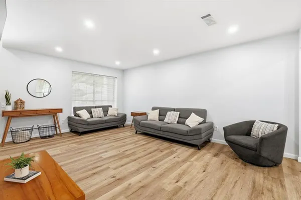 a living room with furniture and a wooden floor