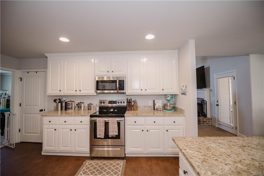 117 Kensington Trace Bethlehem, GA 30620 - Photo 14 of 43 a kitchen with stainless steel appliances kitchen island sink stove and refrigerator
