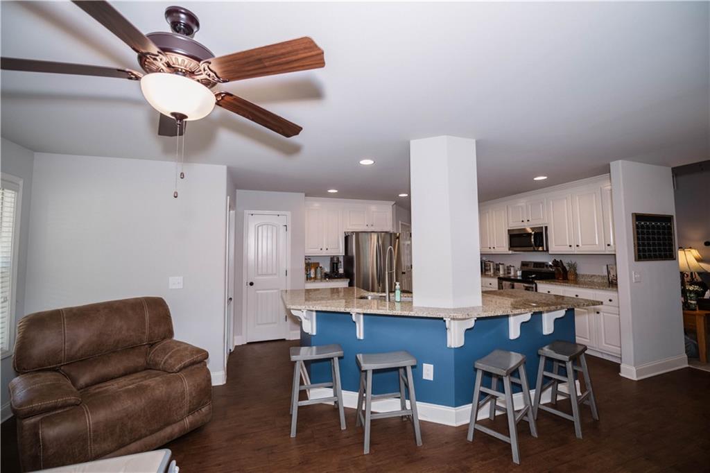 117 Kensington Trace Bethlehem, GA 30620 - Photo 17 of 43 a kitchen with stainless steel appliances kitchen island granite countertop a dining table chairs and a refrigerator