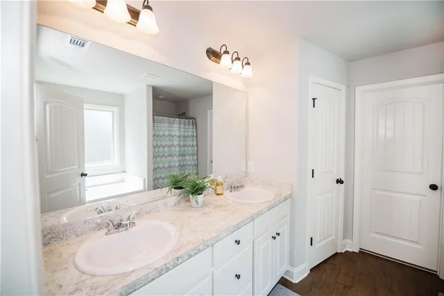 a bathroom with a double vanity sink and a mirror
