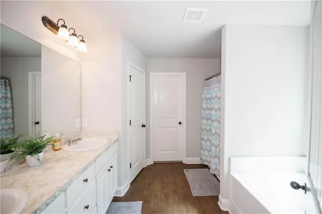 a spacious bathroom with a bathtub sink and mirror