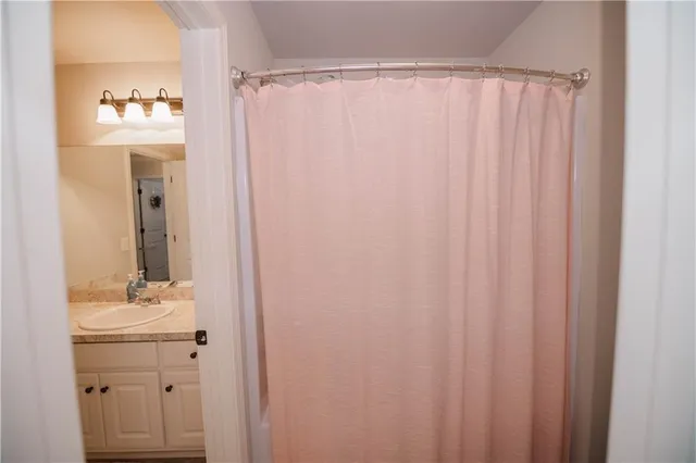 a bathroom with a sink a mirror and a shower curtain
