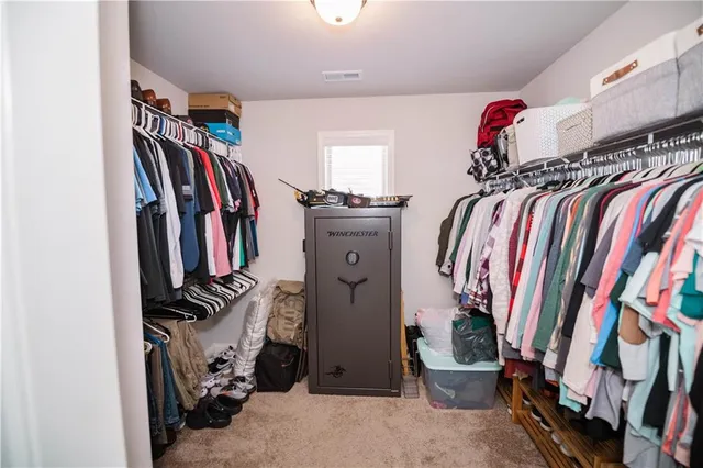 a view of walk in closet with clothes and shoes