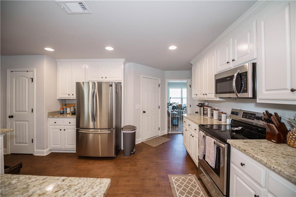 117 Kensington Trace Bethlehem, GA 30620 - Photo 5 of 43 a kitchen with stainless steel appliances granite countertop a refrigerator a stove top oven a sink and dishwasher