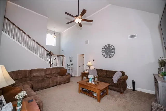 a living room with furniture a clock and a ceiling fan