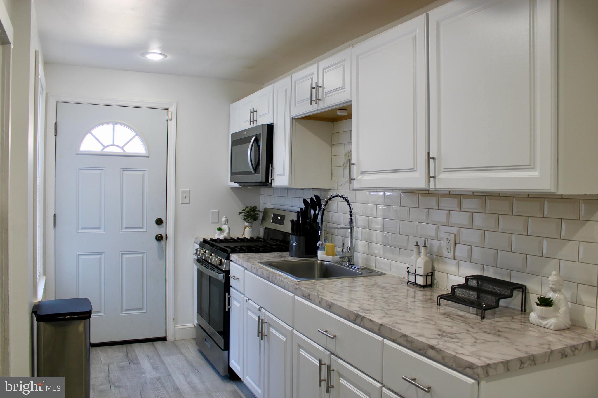 1211 South Octagon Road Camden, NJ 08104 - Photo 2 of 18 a kitchen with sink a microwave and cabinets