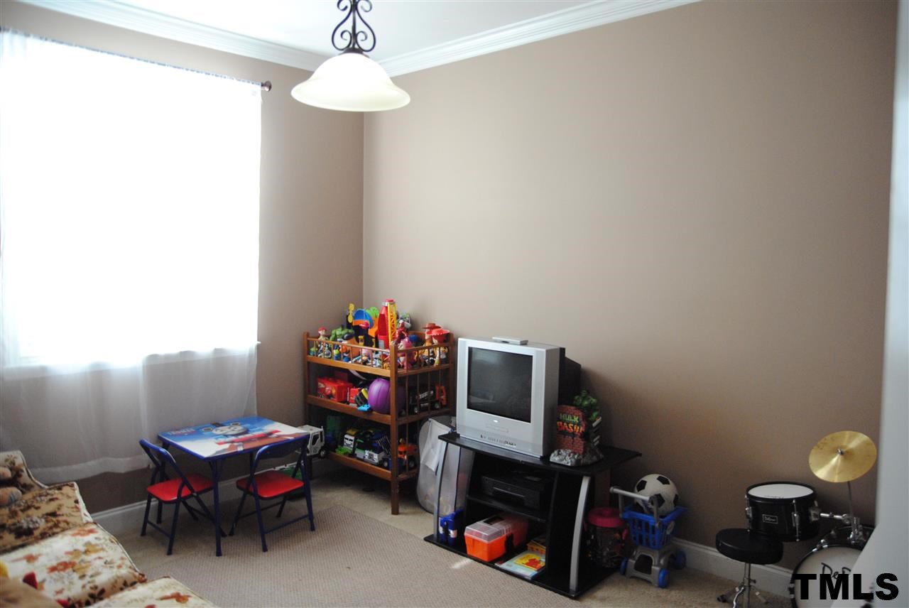 2504 Quarry Ridge Lane Raleigh, NC 27610 - Photo 4 of 16 a living room with a baby crib toys and a couch