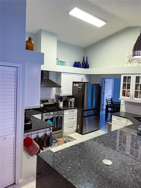 2571 Running Oak Court Spring Hill, FL 34608 - Photo 14 of 37 a kitchen with stainless steel appliances granite countertop a sink stove and refrigerator