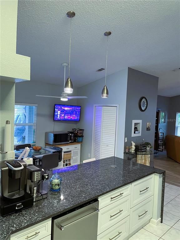 2571 Running Oak Court Spring Hill, FL 34608 - Photo 10 of 37 a kitchen with stainless steel appliances granite countertop a stove a sink and a microwave
