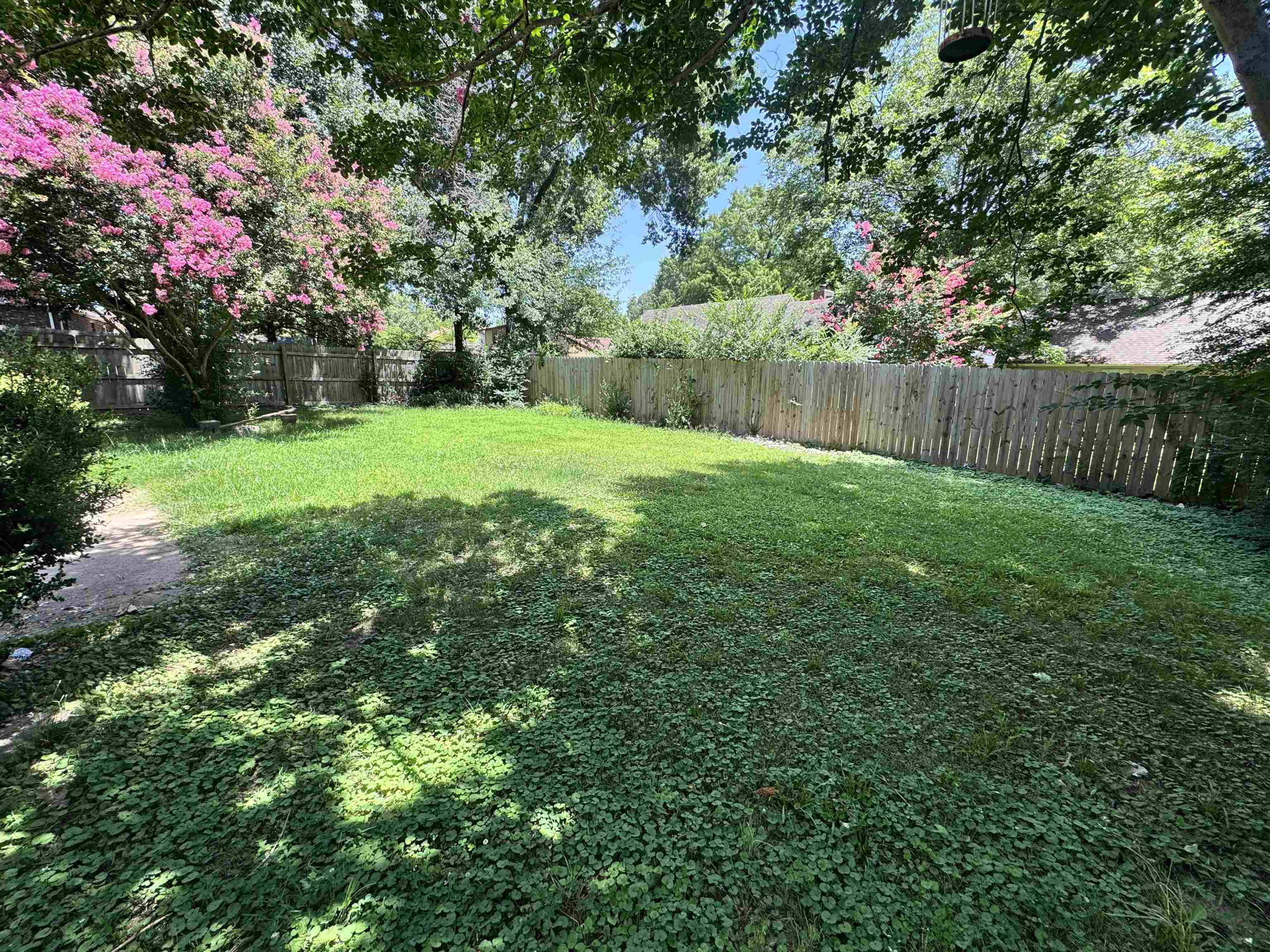 4334 Timber Rise Road Memphis, TN 38125 - Photo 18 of 18 Spacious backyard featuring a perimeter privacy fence, mature trees, and a gravel path