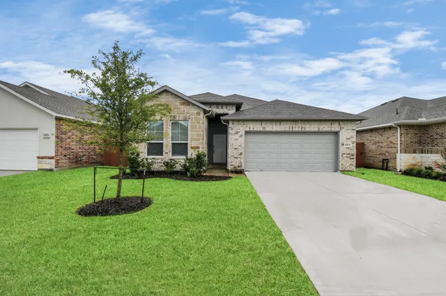 a front view of a house with a yard and a garage