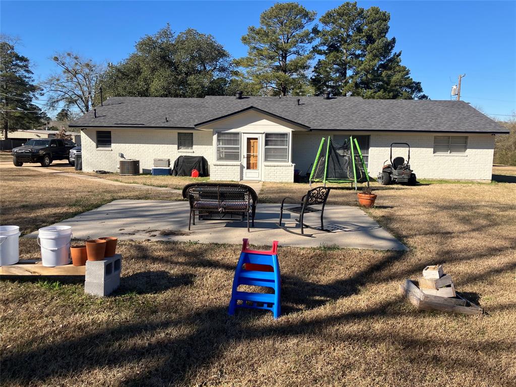233 Church Road Stonewall, LA 71078 - Photo 4 of 32 Back of house featuring a lawn, brick siding, a shingled roof, and a patio