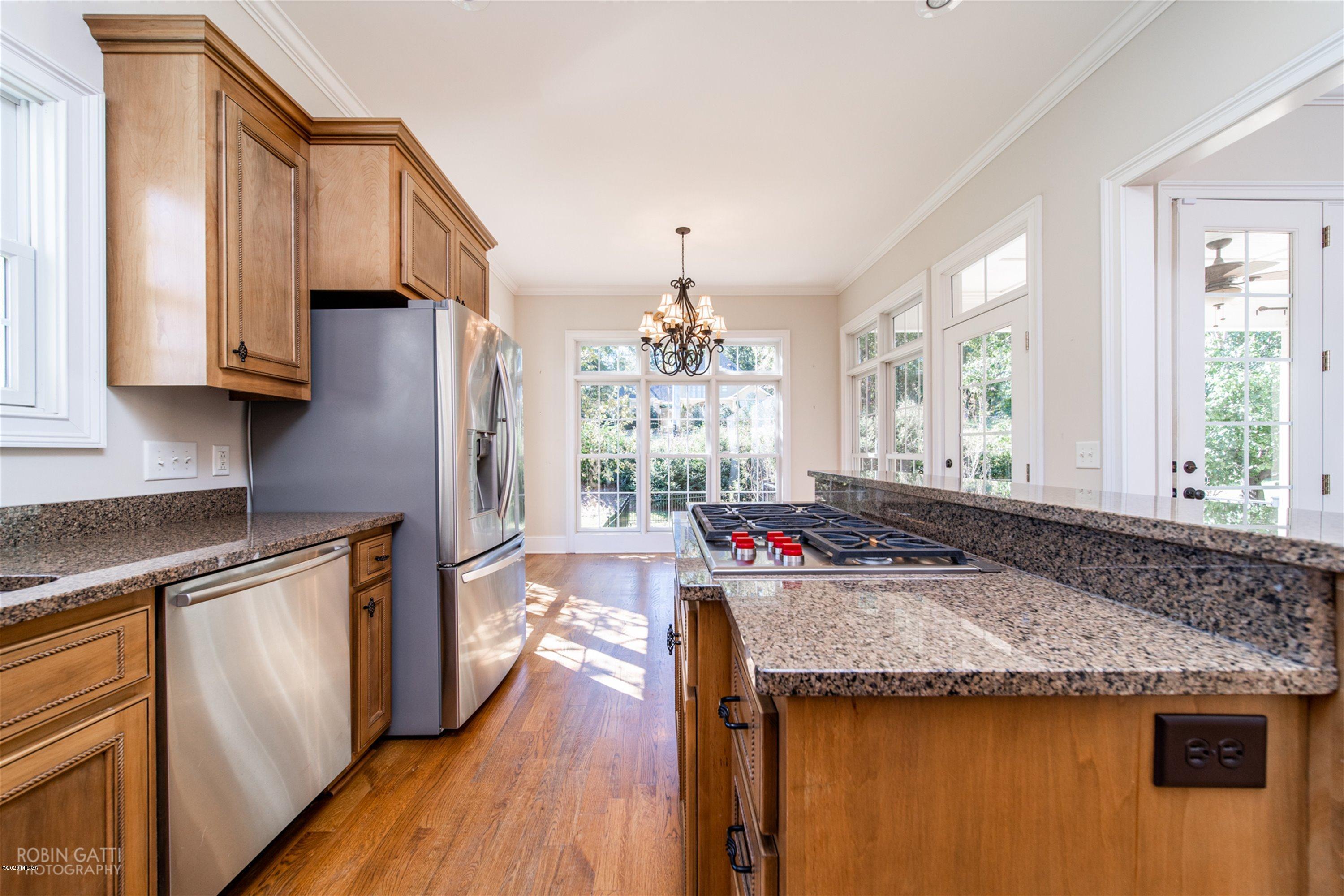5022 Tucker Ridge Macon, GA 31210 - Photo 7 of 38 a kitchen with stainless steel appliances granite countertop a stove and a wooden cabinets