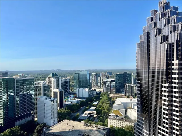a view of a hallway with wooden floor and a bathroom