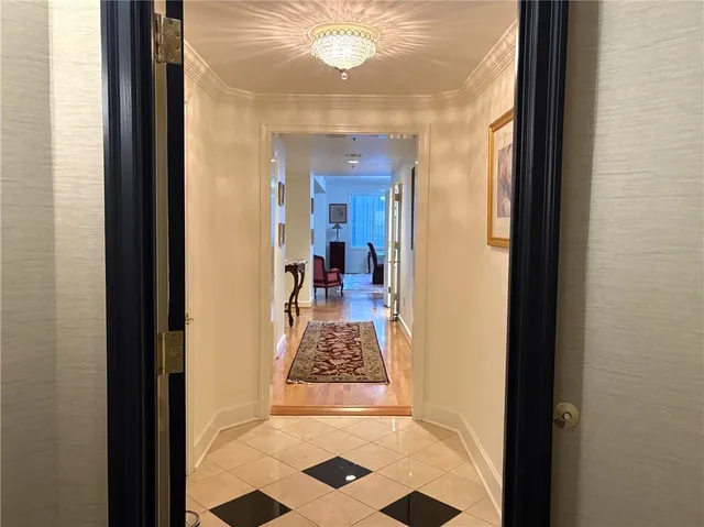 a view of a hallway to a livingroom with furniture
