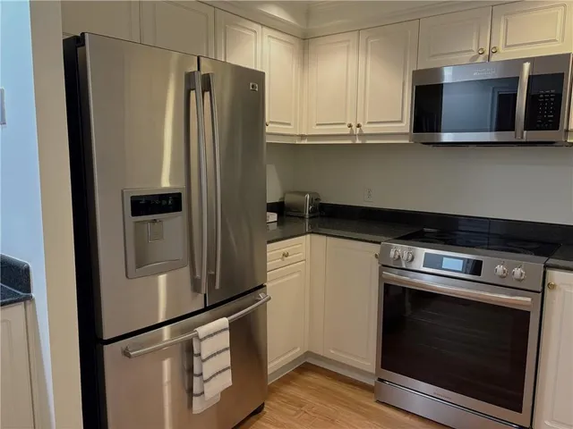 a kitchen with stainless steel appliances granite countertop a refrigerator and a stove top oven