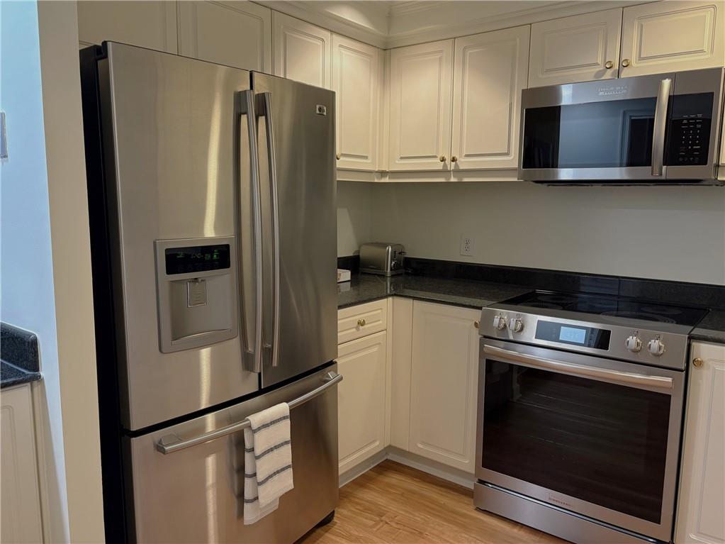 75 14th Street Northeast, Unit 3650 Atlanta, GA 30309 - Photo 4 of 25 a kitchen with stainless steel appliances granite countertop a refrigerator and a stove top oven