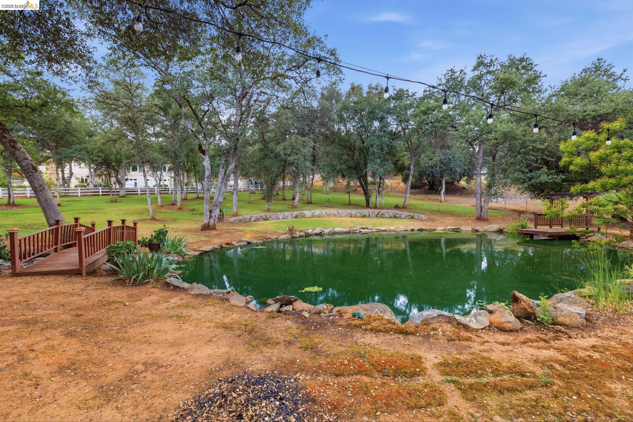 18450 Lambert Lake Road Sonora, CA 95370 - Photo 62 of 87 Landscaped pond featuring a decorative wooden bridge and an accompanying wooden dock