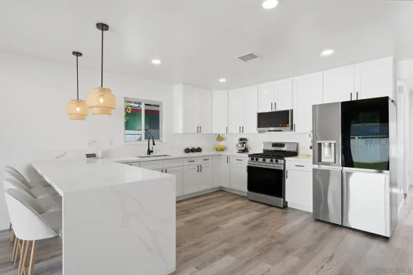 a kitchen with a sink a counter top space stainless steel appliances and cabinets