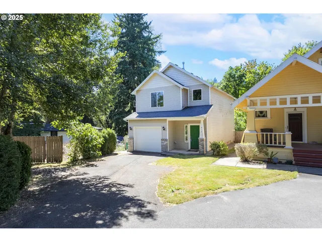 a view of house with yard and tree in front of it