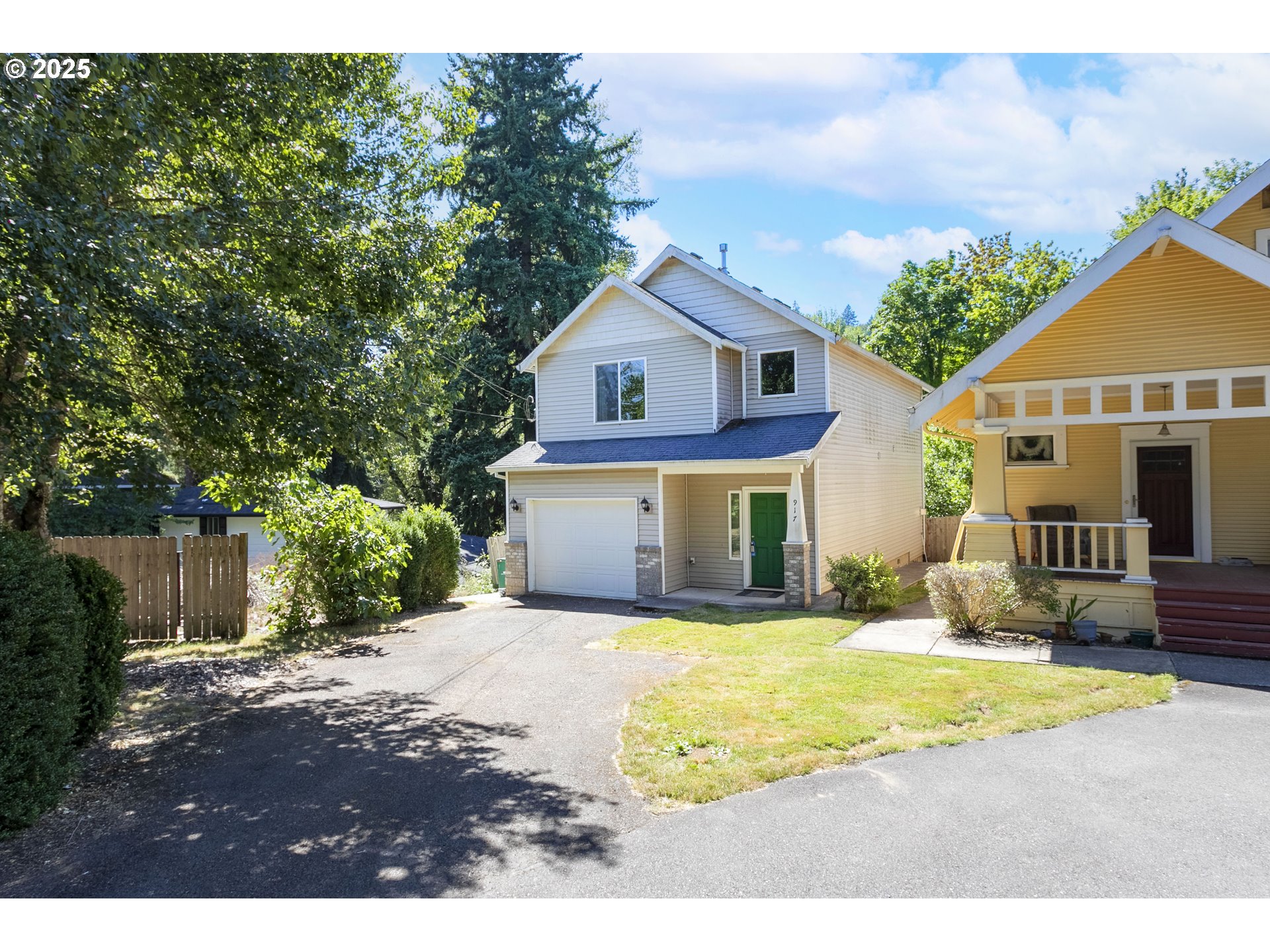 a view of house with yard and tree in front of it