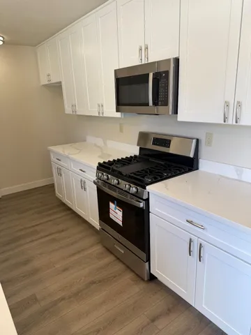 a kitchen with granite countertop a sink a counter space and cabinets
