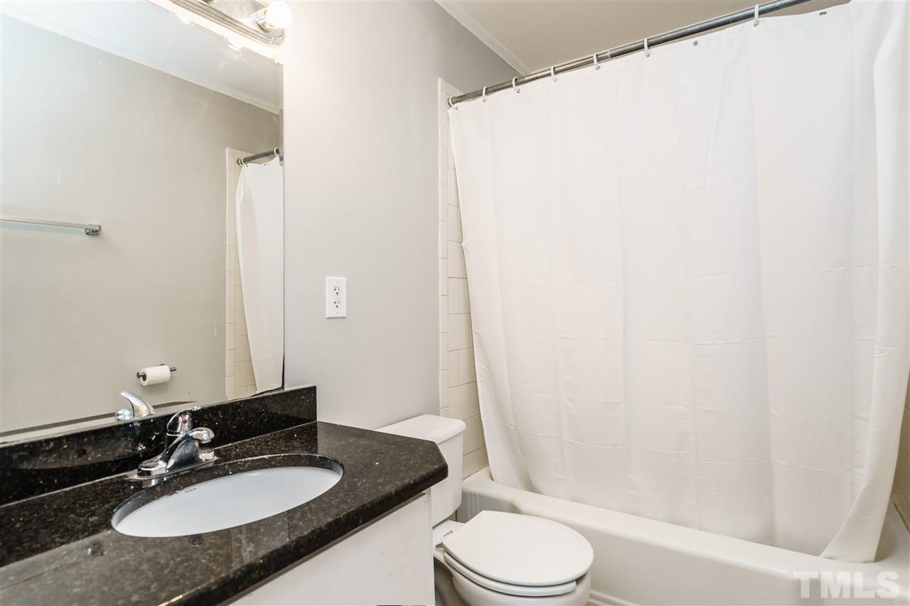 2732 Layden Street Raleigh, NC 27603 - Photo 16 of 19 a bathroom with a granite countertop sink toilet a mirror and shower