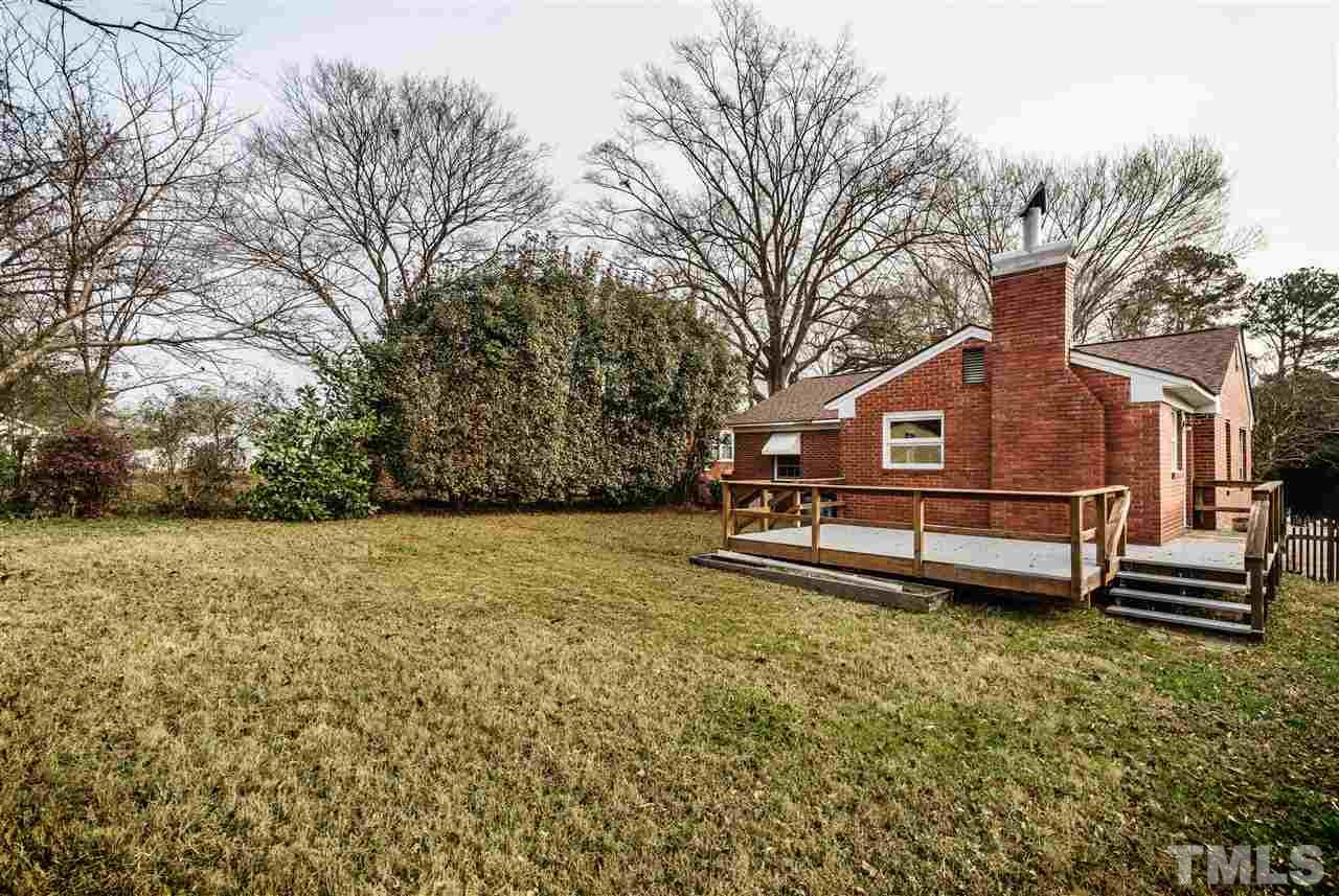 2732 Layden Street Raleigh, NC 27603 - Photo 19 of 19 a backyard of a house with large trees and outdoor seating
