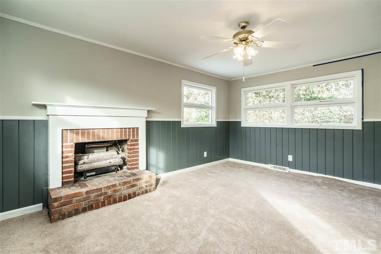 2732 Layden Street Raleigh, NC 27603 - Photo 8 of 19 a view of an empty room with a fireplace and a window