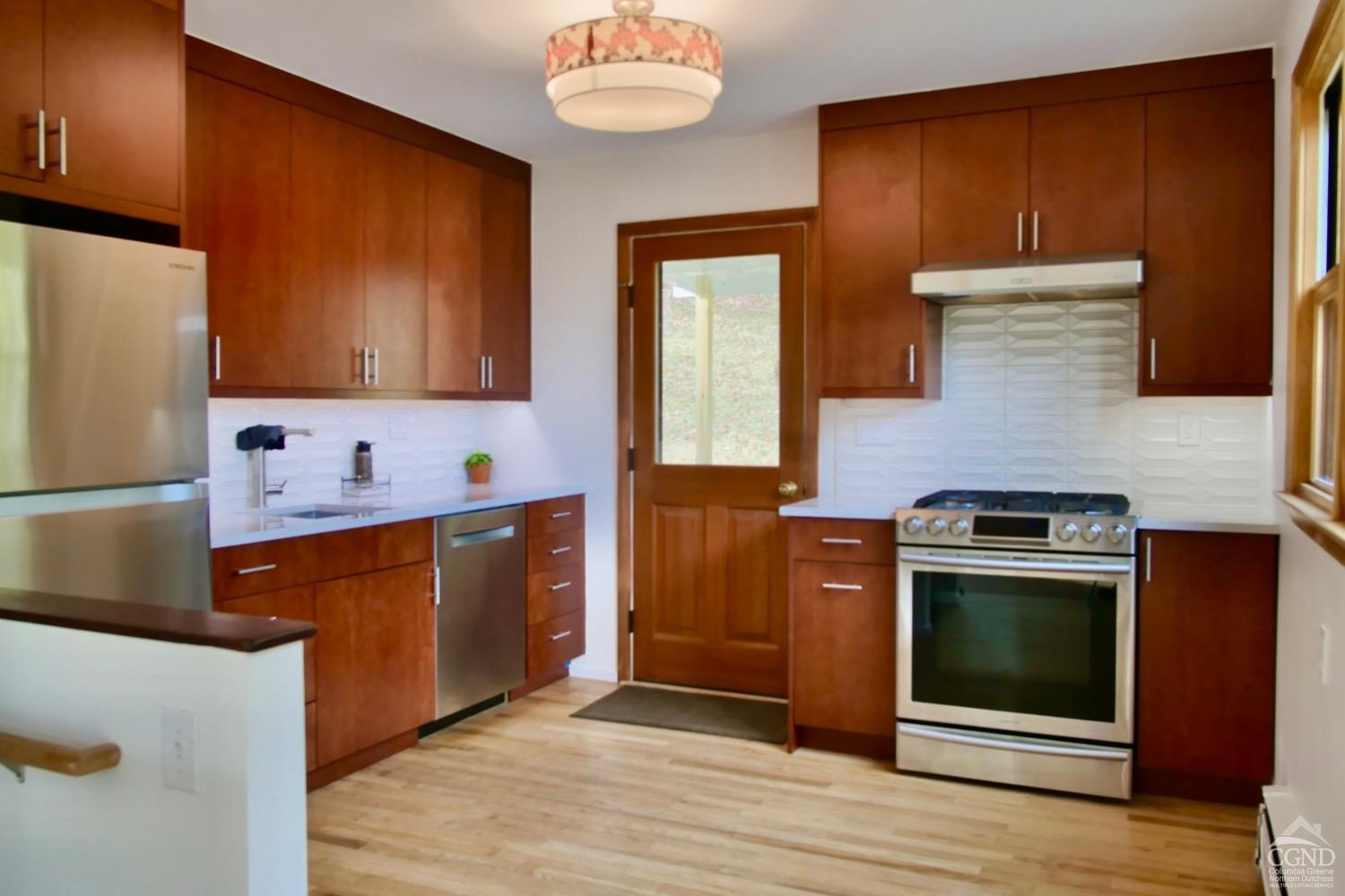 a kitchen with stainless steel appliances granite countertop wooden cabinets a stove and a refrigerator