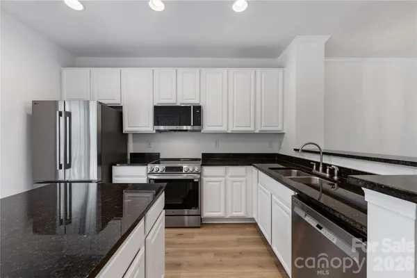 a kitchen with stainless steel appliances granite countertop a stove a refrigerator and a sink