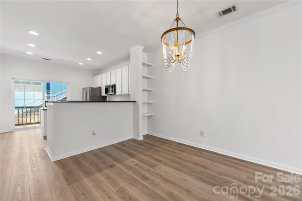 a view of a kitchen with wooden floor and a window