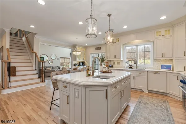 a kitchen with stainless steel appliances kitchen island granite countertop a table chairs and a stove