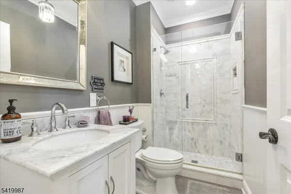 a view of a dining room with furniture a chandelier and wooden floor
