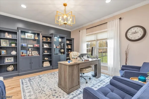 a kitchen with stainless steel appliances granite countertop a refrigerator a sink dishwasher a dining table and chairs with wooden floor