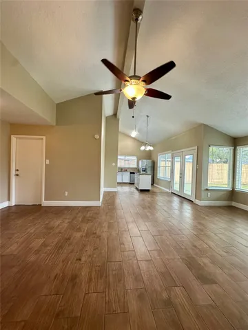 a view of a hallway with wooden floor and staircase