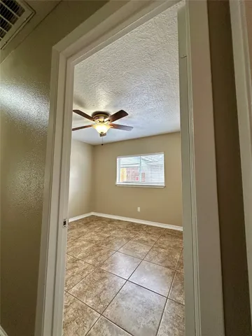 a view of a backyard with a large tree and wooden fence
