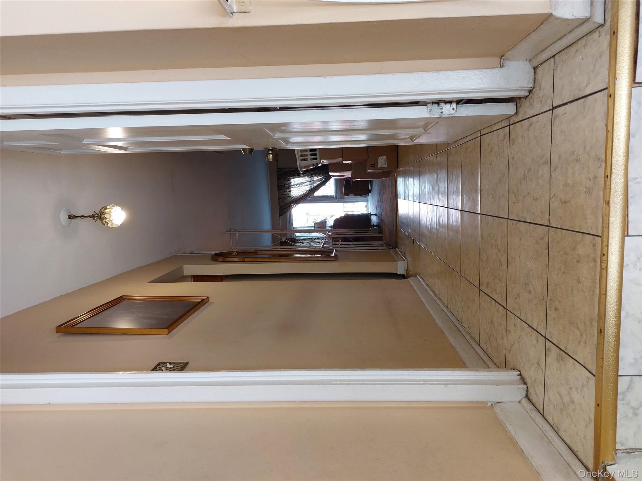 108-19 48th Avenue Queens, NY 11368 - Photo 6 of 21 Hallway featuring baseboards and light tile patterned floors