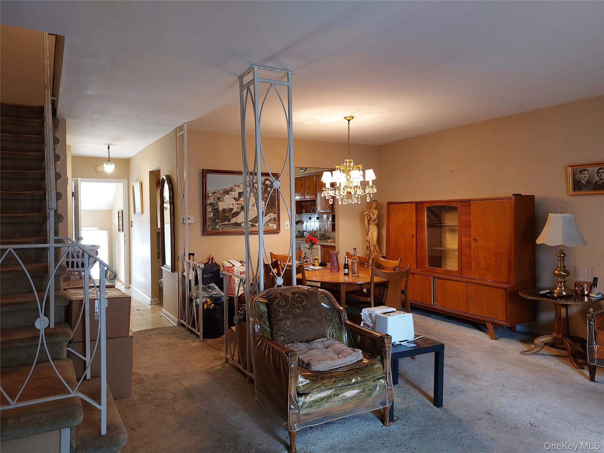 108-19 48th Avenue Queens, NY 11368 - Photo 7 of 21 Carpeted living area featuring stairway and a chandelier
