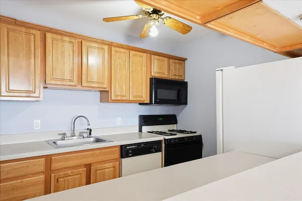 a kitchen with granite countertop a sink stainless steel appliances and cabinets