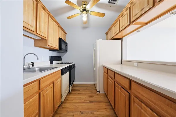 a kitchen with stainless steel appliances granite countertop a sink and dishwasher a oven with white cabinets