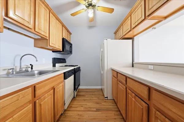 a kitchen with stainless steel appliances granite countertop a sink and dishwasher a stove with wooden floor