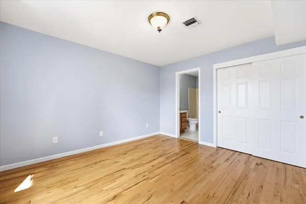 a view of empty room with wooden floor