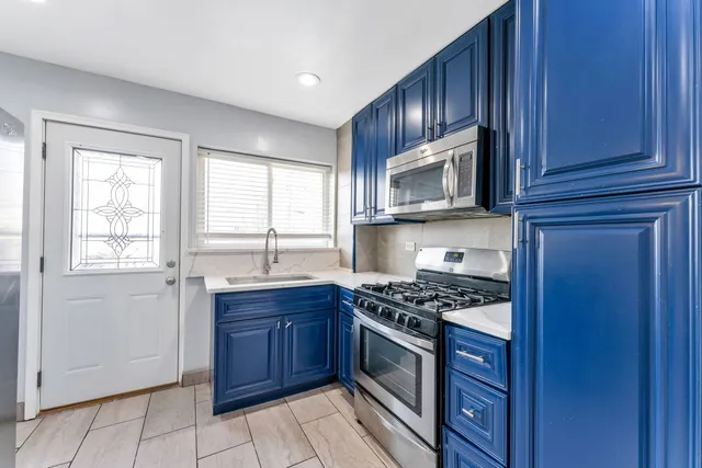 a kitchen with granite countertop wooden cabinets stainless steel appliances and a window