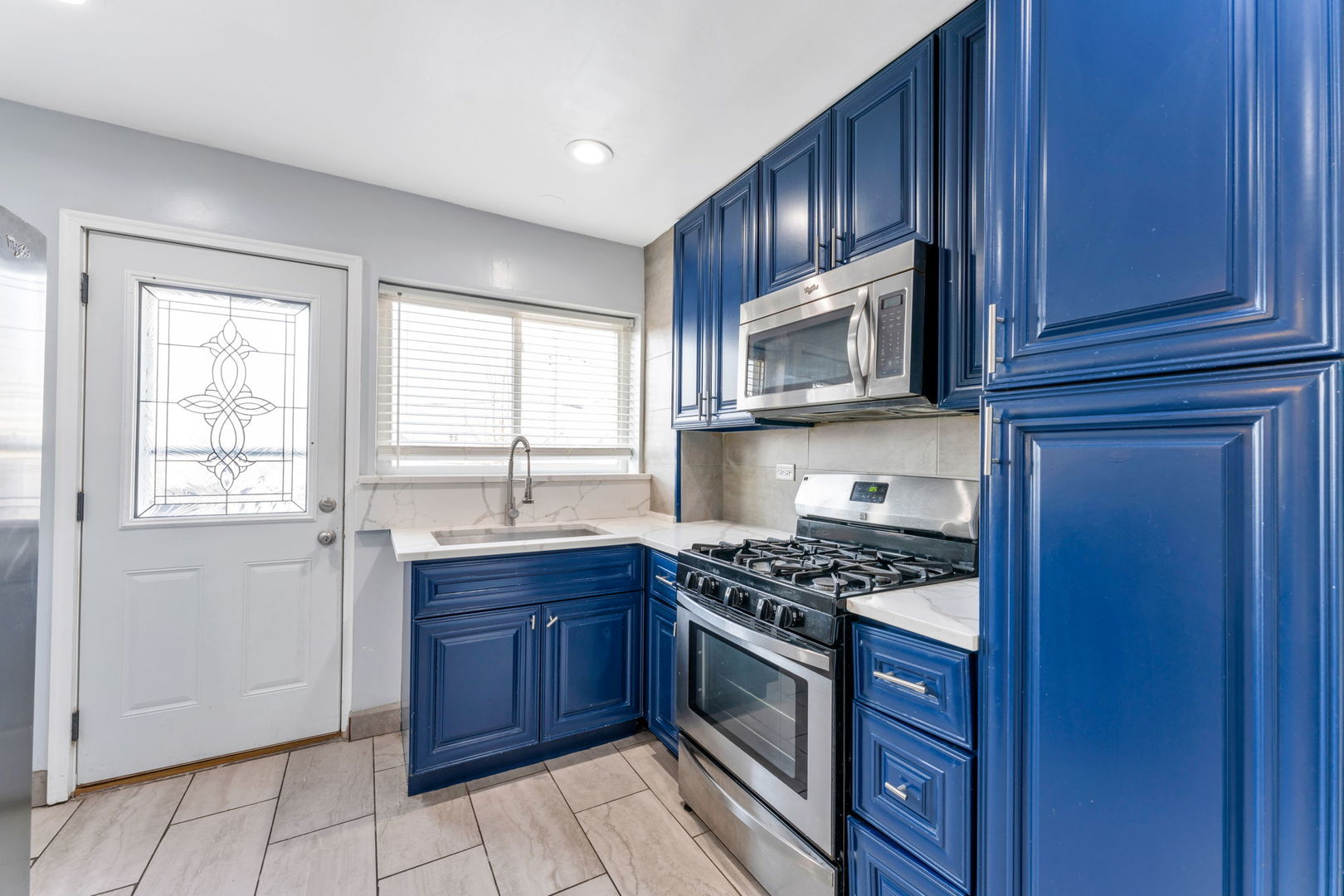 3142 54th Court Cicero, IL 60804 - Photo 3 of 15 a kitchen with granite countertop wooden cabinets stainless steel appliances and a window